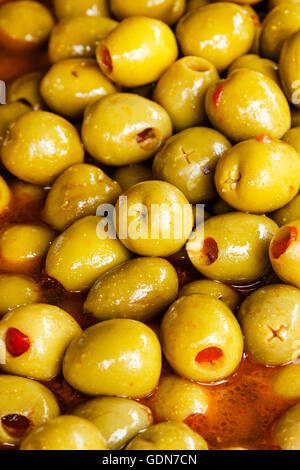 Rote Paprika gefüllte Oliven auf einem traditionellen Handwerker-Markt. Vertikales Bild. Stockfoto