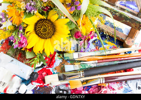 Palette mit Malerei Material und einem Bouquet von Sommerblumen. Stockfoto