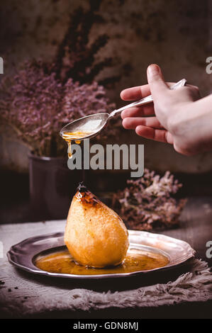 Pochierte Birne mit Honig-Sauce - Poire Belle Hellene in eine rustikale Stimmung Stockfoto