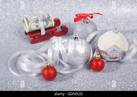 Geld nach Hause bringt der Weihnachtsmann auf seinem Schlitten auf Glitzer Hintergrund Stockfoto