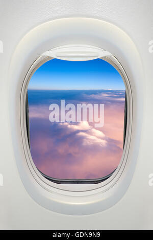 Fenster eines Flugzeugs von innen, Blick auf ein Meer von Wolken Stockfoto