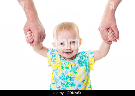 Baby, die ersten Schritte mit Hilfe der Mutter des Vaters auf weißem Hintergrund Stockfoto