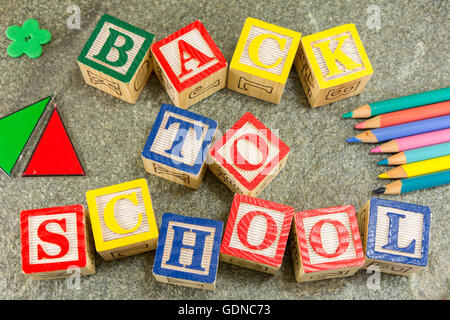 Zurück zur Schule geschrieben mit Holzbuchstaben und Lerntools Stockfoto