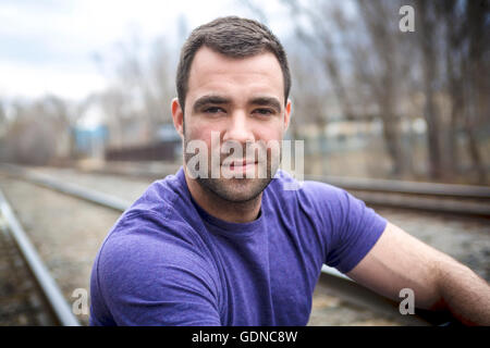netter junger Mann Porträt auf der Eisenbahn Stockfoto
