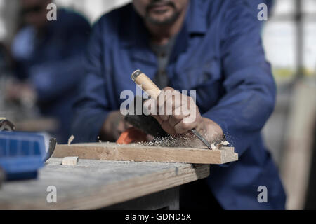 Händen der Tischler mit Meißel auf Holz in Werkstatt Stockfoto