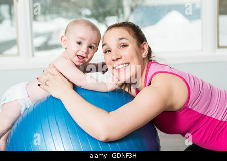 Mutter mit Kind junge Fitness-Übungen Stockfoto