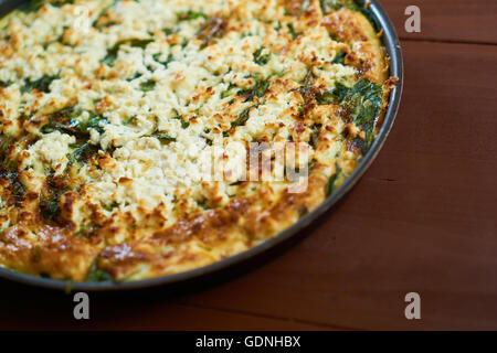 Frittata in einer Pfanne mit Spinat und Käse auf der Oberseite Stockfoto