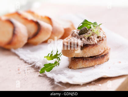 Fisch Pastete Ausbreitung hautnah mit Toast, Kapern und Rucola Stockfoto