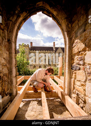 Vorbereitungen für das 950. Jubiläumsjahr der Schlacht von Hastings kurz vor dem Abschluss in der Battle Abbey mit English Heritage. Ein Zimmermann installiert neue Eiche-gerahmte Schritte ermöglichen Besucher Zugriff auf das Wohnheim zum ersten Mal. Stockfoto