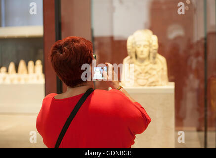 Besucherin fotografiert Lady von Elche bei National Archeological Museum von Madrid Stockfoto