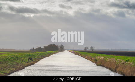 Cambridgeshire Fens, zwei Männer, die Fische, die in den künstlichen Wasserstraße, durch die Bedford Ebene in Cambridgeshire Moorland, East Anglia, England, UK. Stockfoto