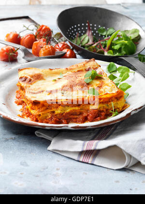Essen, vegetarisch, gebratener Butternut-Kürbis-Lasagne, Käse, Tomaten, Salat, Vintage Platte, rustikale Metall Sieb Stockfoto