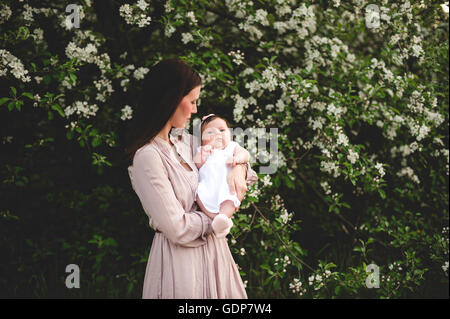 Porträt von Mädchen in armen Mütter von Garten Apfelblüte Stockfoto