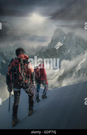 Zwei Bergsteiger auf einen verschneiten Hang beobachten den Grand Jorasses im Mont-Blanc-Massiv, Chamonix, Frankreich Stockfoto