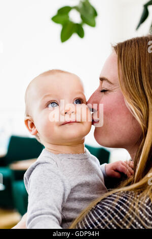 Frau mit Tochter und ihre Wange küssen Stockfoto