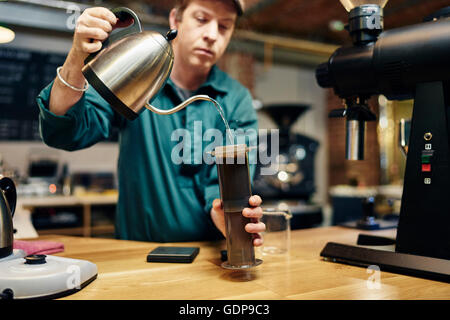 Männliche Barista, die Zubereitung von Kaffee in Coffee-shop Stockfoto