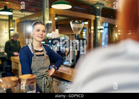 Weibliche Barista servieren Kunden in Coffee-shop Stockfoto