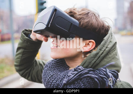 Junge Frau im Freien, virtual-Reality-Kopfhörer tragen Stockfoto