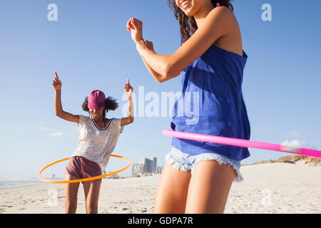 Frauen am Strand mit Hula hoops Stockfoto