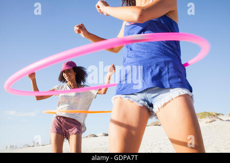 Frauen am Strand mit Hula hoops Stockfoto