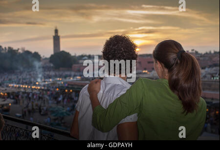 Rückansicht des Paares Blick auf Sonnenuntergang über Djemaa el-Fna Platz bei Sonnenuntergang, Marrakesch, Marokko Stockfoto