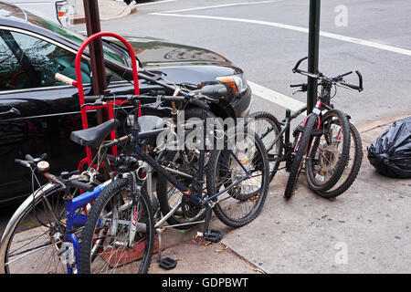 NEW YORK CITY - 10. Oktober 2014: viele Defekte und abgenutzte Fahrrad Wracks gesperrt, um Polen an einer Ecke im East Village zu unterzeichnen Stockfoto