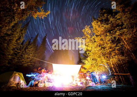 Langzeitbelichtung der Sterne am Nachthimmel und Lichtspuren Lagerfeuer, Elinor See Naherholungsgebiet, Naramata, BC, Kanada Stockfoto