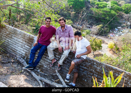 Drei junge Mexikaner Jungs sitzen auf einer Mauer in der mexikanischen Landwirtschaft Stockfoto