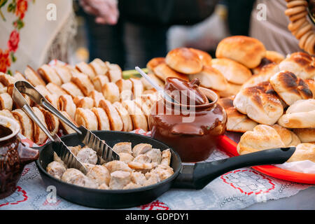 Die Gerichte der traditionellen belarussischen Küche - gebratenen Speck und Fleisch Wurst, Gebäck. Stockfoto