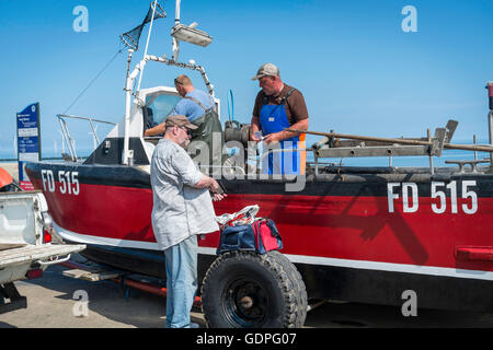 Ein Mann Kauf frisch gefangenen Fisch aus einem Küstenfischerei Boot in Redcar und Cleveland, UK. Stockfoto