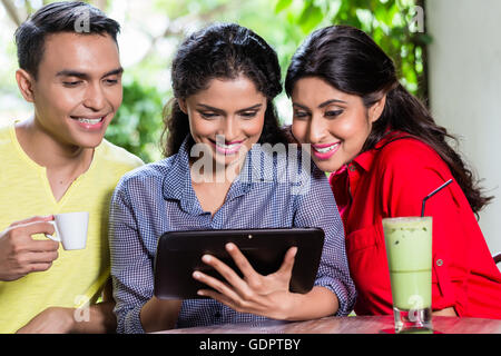 Gruppe von jungen Indianern Blick auf Tablet-Computer beim Sitzen im café Stockfoto