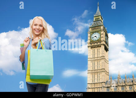 junge glückliche Frau mit Einkaufstüten über big ben Stockfoto