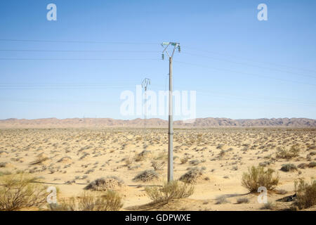 Stromleitungen in felsige Wüste zu Beginn des Sahara mitten in Tunesien. Stockfoto