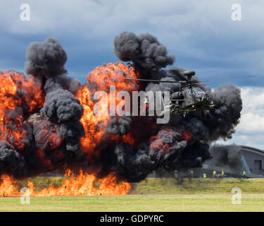 Britische Armee Apache Helikopter feuert Raketen zur Explosion führen. Foto von Apache-Hubschrauber mit Flammen und Rauch. Stockfoto