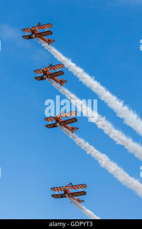 4 Orange Boeing Stearman Doppeldecker, die Bestandteil der Breitling Wingwalker Kunstflug Ausbildungs-team Stockfoto