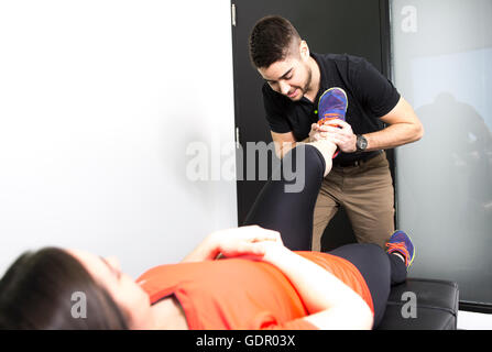 Männliche Osteopath Behandlung von weiblichen Patienten mit Hüft-Problem Stockfoto
