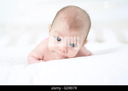 niedliche zwei Monate altes Mädchen im Bett liegend Stockfoto