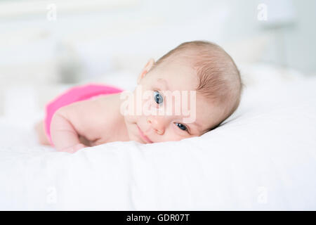 niedliche zwei Monate altes Mädchen im Bett liegend Stockfoto