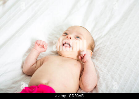niedliche zwei Monate altes Mädchen im Bett liegend Stockfoto
