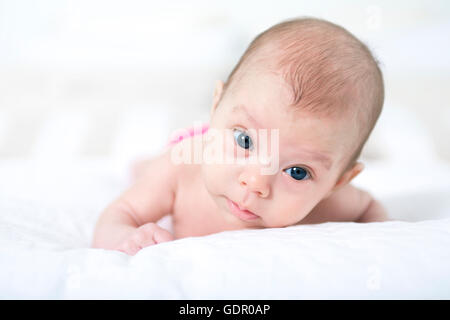 niedliche zwei Monate altes Mädchen im Bett liegend Stockfoto