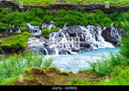 Hraunfossar Wasserfälle eine sehr schöne Wasserfälle in westlich von Island. Die klaren Wasser sickert durch die Lava und Kaskadierung Stockfoto