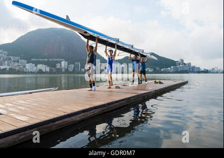 RIO DE JANEIRO - 1. April 2016: Mitglieder der Vasco da Gama rowing Club tragen ihr Boot zurück zum Clubhaus in Lagoa. Stockfoto