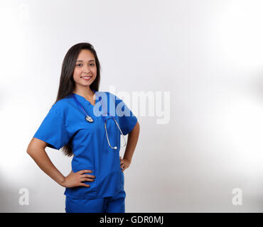 Eine freundliche Krankenschwester lächelt an der Kamera, während sie stolz ihr Stethoskop trägt. Stockfoto