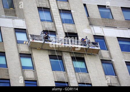 Fensterwaschmaschinen reinigen einen Wolkenkratzer in Lower Manhattan (Wall Street Gebäude 120), New York City, NY, USA Stockfoto