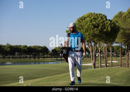 schöne orientalische Golfer Tragetasche und zu Fuß zum nächsten Loch am Golfplatz Stockfoto