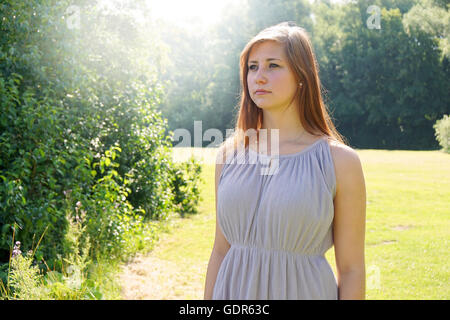 junge Frau in einem Park mit Sonne flare Stockfoto