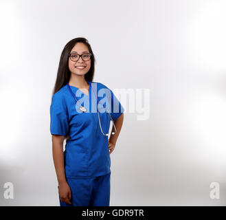 Eine fröhliche Krankenschwester in blauen Schrubben, die bereit ist zu helfen. Stockfoto