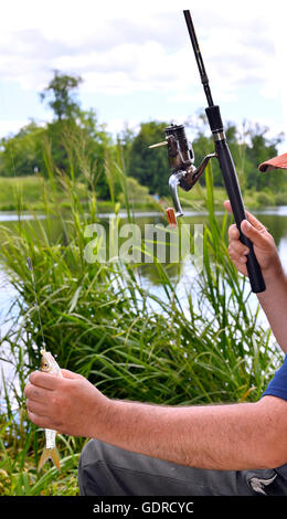 Nahaufnahme der Kerl sitzt auf der Brücke und Angeln Stockfoto