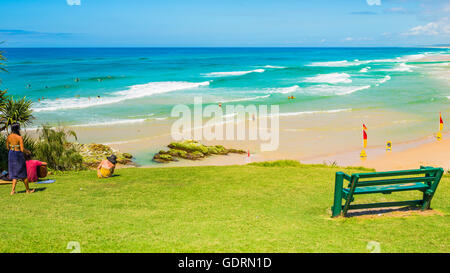 Menschen, die etwas Musik zu genießen, während Sie gemütlich auf dem Rasen mit Blick auf einen schönen Strand von North Stradbroke Island Stockfoto