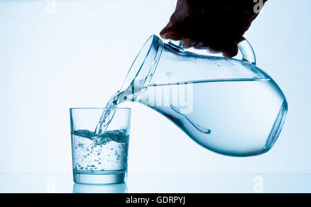 Wasser aus einem Krug in ein Glas gegossen Stockfoto